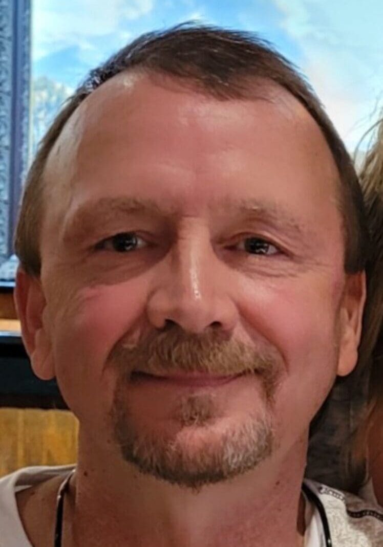 Smiling man with brown hair and beard.